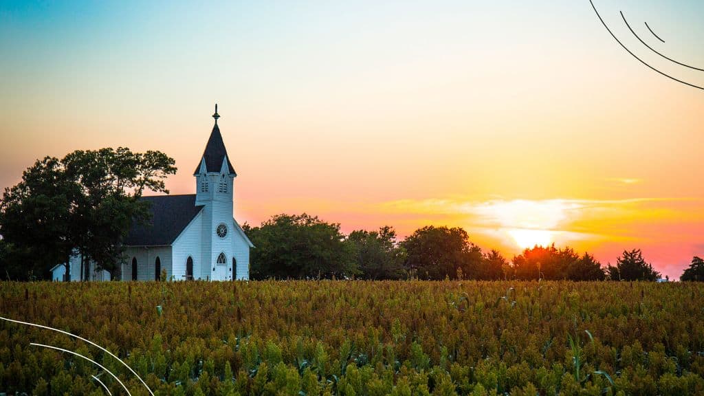 Picture of a church across the field at sunset - Church anniversary invitation Letter at Church Ministry Help