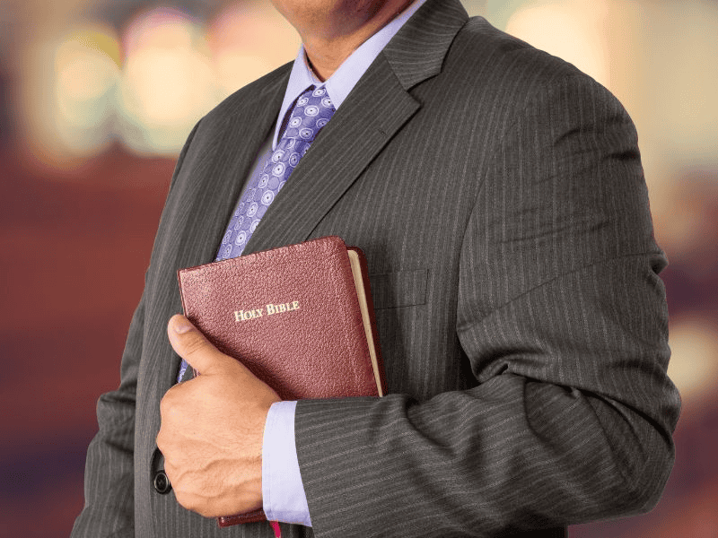 man holding Bible wearing suit in a church