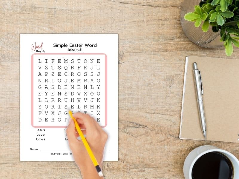 easter word search printable - hand poised with pencil over a word search on top of a desk (2)
